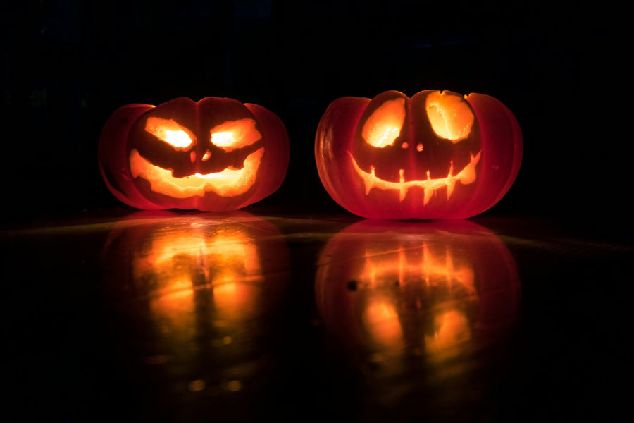 Two glowing jack-o'-lanterns at night